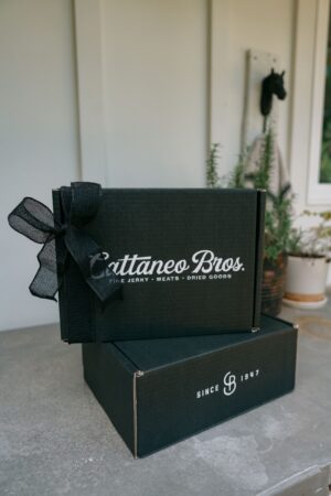 Stacked Cattaneo Bros. black gift boxes with bow