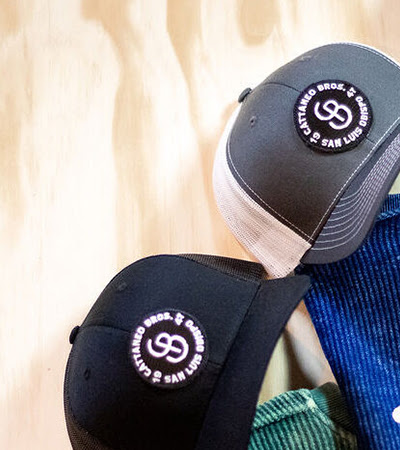 Two black trucker caps with circular logo