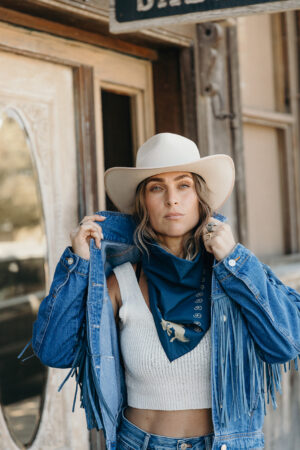Woman in cowboy hat, denim fringe jacket